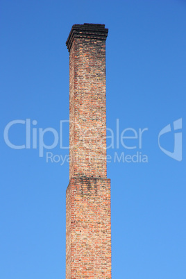 one orange brick pipe on blue sky.