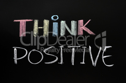 Think positive - text written with chalk on blackboard