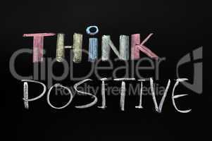 Think positive - text written with chalk on blackboard