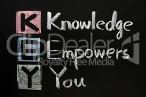 KEY acronym - Knowledge empowers you on a blackboard with words written in chalk.