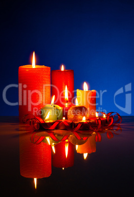 A lot of burning colorful candles against black background