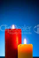 Five burning colourful candles against blue background
