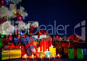 Christmas presents and burning candles against blue background