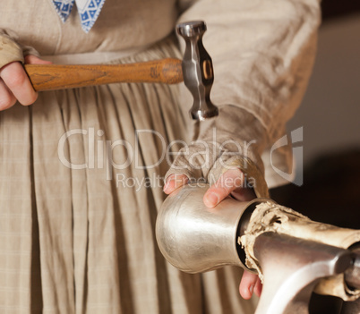 Lady hammering silver mug