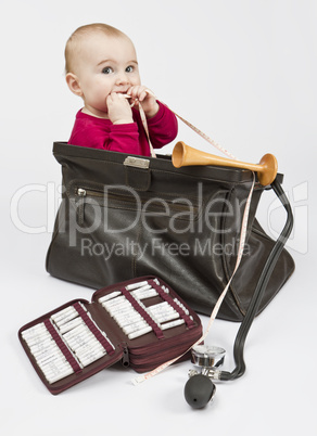 young child sitting in midwifes case