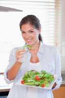 Portrait of a happy woman eating a salad