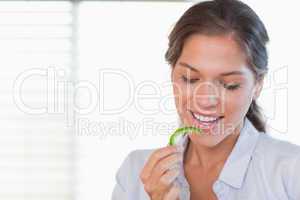 Happy woman eating a slice of pepper