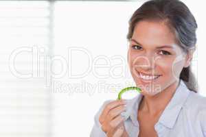 Cheerful woman eating a slice of pepper