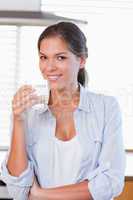 Portrait of a smiling woman holding a glass of water