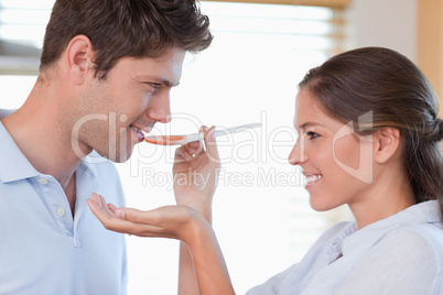 Close up of a man tasting his wife's sauce