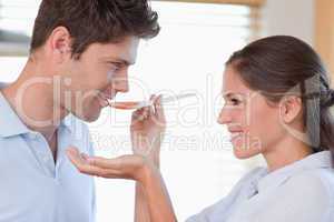 Close up of a man tasting his wife's sauce