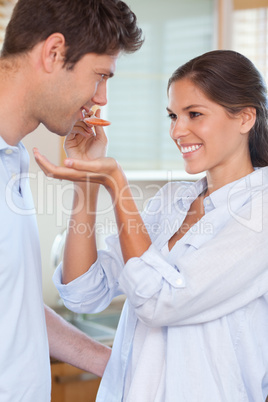 Portrait of a man tasting his wife's sauce