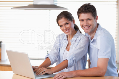 Smiling couple using a laptop