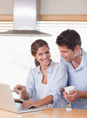 Portrait of a couple using a laptop while having tea