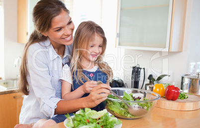 Mother and her daughter preparing a salad