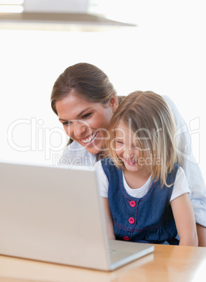 Portrait of a mother and her daughter using a notebook