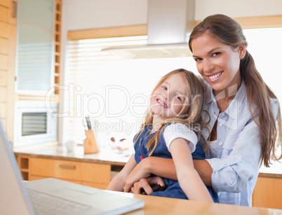 Happy mother and her daughter using a laptop