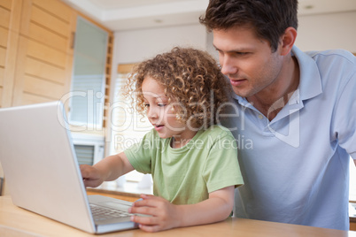 Boy and his father using a notebook