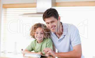 Smiling boy and his father using a tablet computer