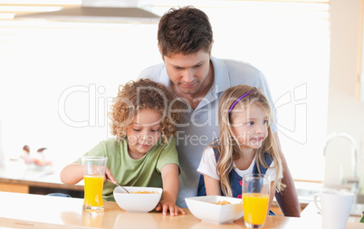 Young father with his children having breakfast