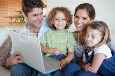 Smiling family using a laptop Smiling family using a laptop
