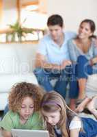 Portrait of children using a tablet computer while their parents