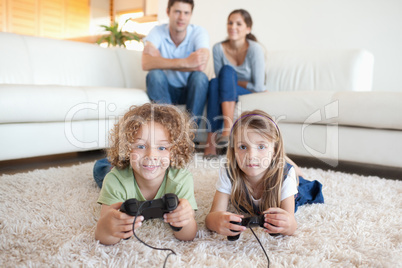Children playing video games while their parents are watching