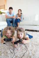 Portrait of children playing video games while their parents are