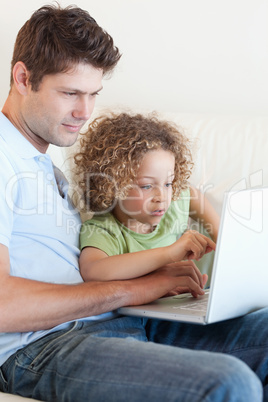 Portrait of a young boy and his father using a laptop