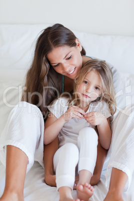 Portrait of a mother and her daughter posing on a bed