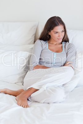 Portrait of a young woman sitting on her bed