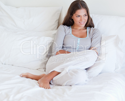 Woman sitting on her bed