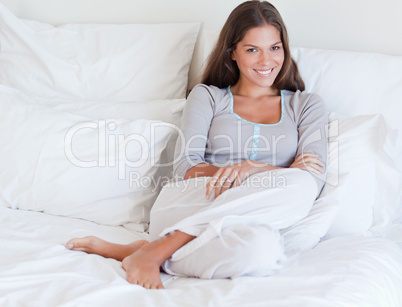 Smiling woman sitting on her bed