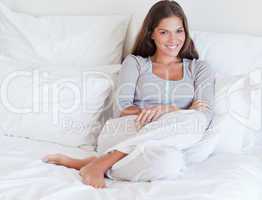 Smiling woman sitting on her bed