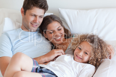 Family relaxing on a bed