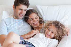 Family relaxing on a bed