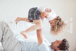 Side view of smiling father lifting child
