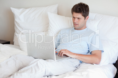 Man lying in bed with laptop Man lying in bed with laptop