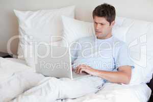 Man lying in bed with laptop