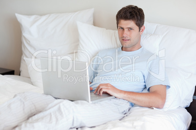 Man lying in bed with notebook Man lying in bed with notebook