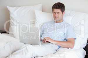 Man lying in bed with notebook