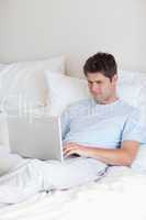 Man surfing the internet in bed
