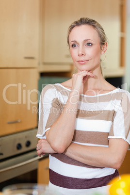 Woman in thoughts standing in kitchen