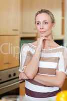Woman in thoughts standing in kitchen
