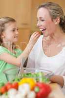 Girl feeding her mother with salad
