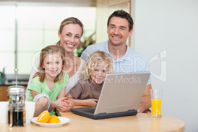 Smiling family using the internet in the kitchen