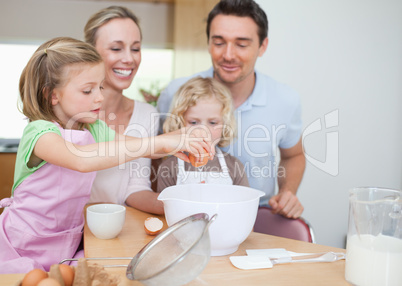 Happy family preparing dough together