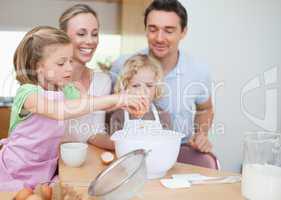 Happy family preparing dough together