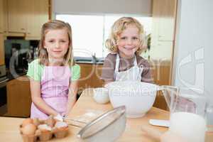 Smiling siblings preparing dough