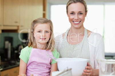Mother and daughter with bowl in the kitchen